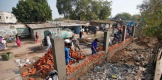 डोनाल्ड ट्रंप की यात्रा से पहले झुग्गियां ढंकने के लिए दीवार बना रहा है नगर निगम